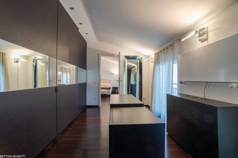 modern interior with black furniture, glass panels, curtains, lamp, hallway leading to bedroom
