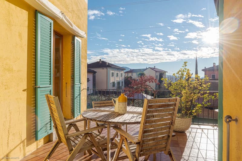 yellow walls, wooden chairs, wooden table, balcony, plants, city view