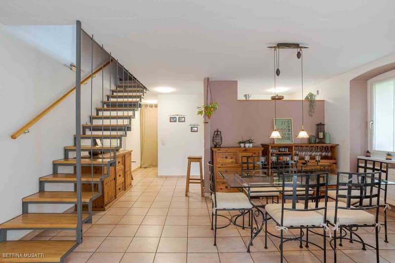 wooden floor, glass table, modern chairs, bar stool, wooden shelves, dining room lamps, staircase