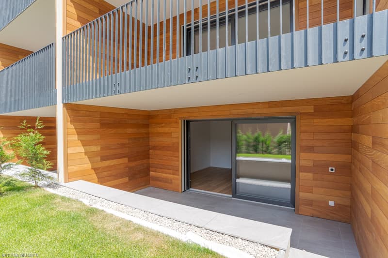 wooden wall, gray floor, gray balcony railing, metal door