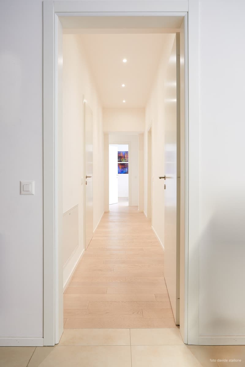 corridor, white walls, white ceiling, hardwood floor, recessed ceiling lights