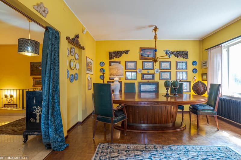 dining room, wooden table, green chairs, chandelier, yellow walls, picture frames