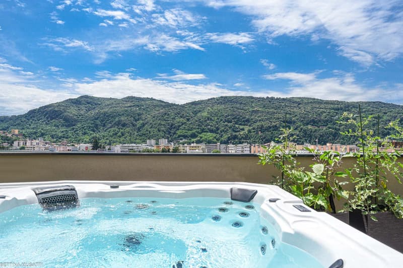 Outdoor area with Jacuzzi, plants, city skyline view