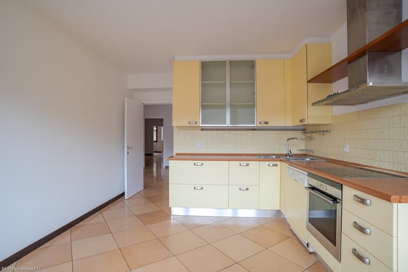 modern kitchen, yellow cabinets, ceramic tiled floor, stainless steel dishwasher, white countertop, gas stove