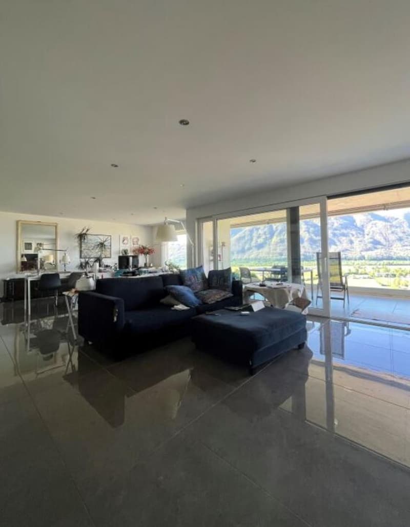 modern living room with large windows and sliding doors leading to balcony, large sofa, coffee table, and modern floor lamp