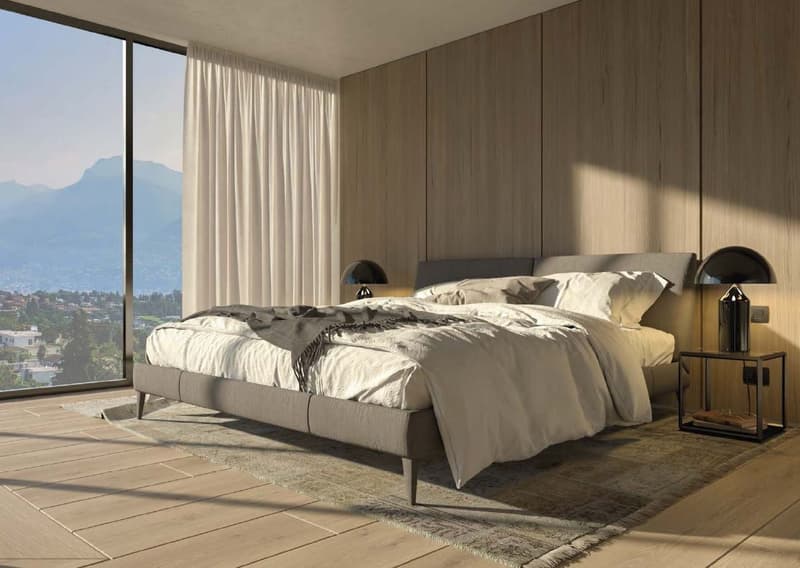Spacious bedroom with large windows offering a scenic view, wooden paneled walls, a king-size bed with neutral-colored bedding, and side tables with lamps.