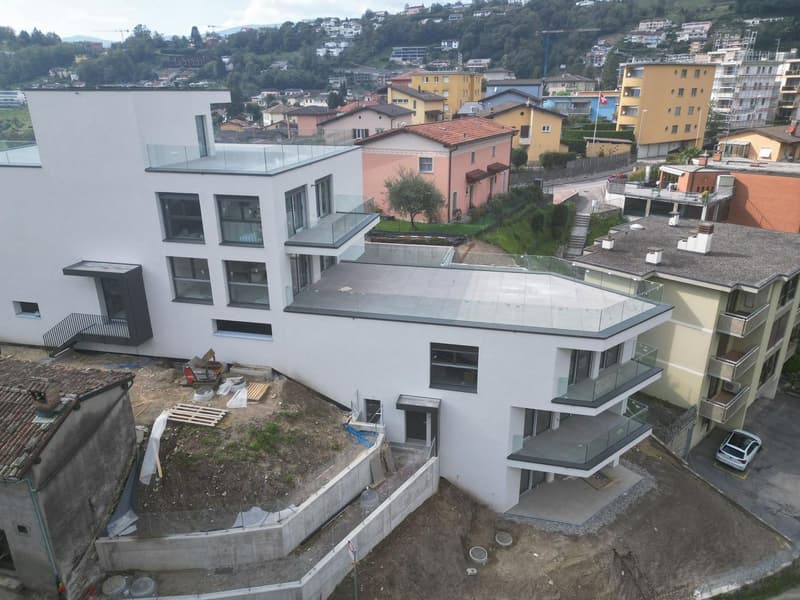 Newly built modern 4-story house with glass balconies, roof terrace, underground parking, located on a slope