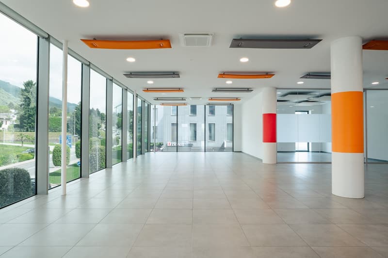 Modern office space with white and orange columns, glass walls, large windows