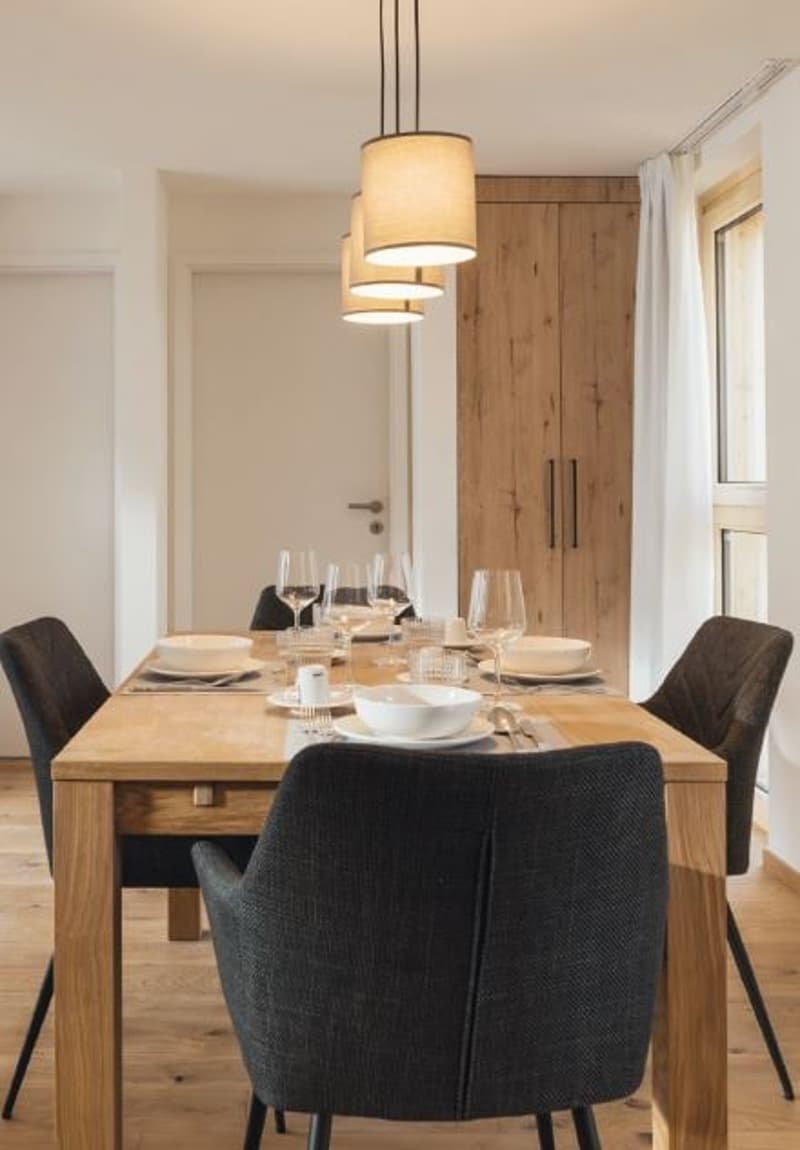 Wooden dining table, 4 chairs, wooden cupboard, chandeliers, white curtains