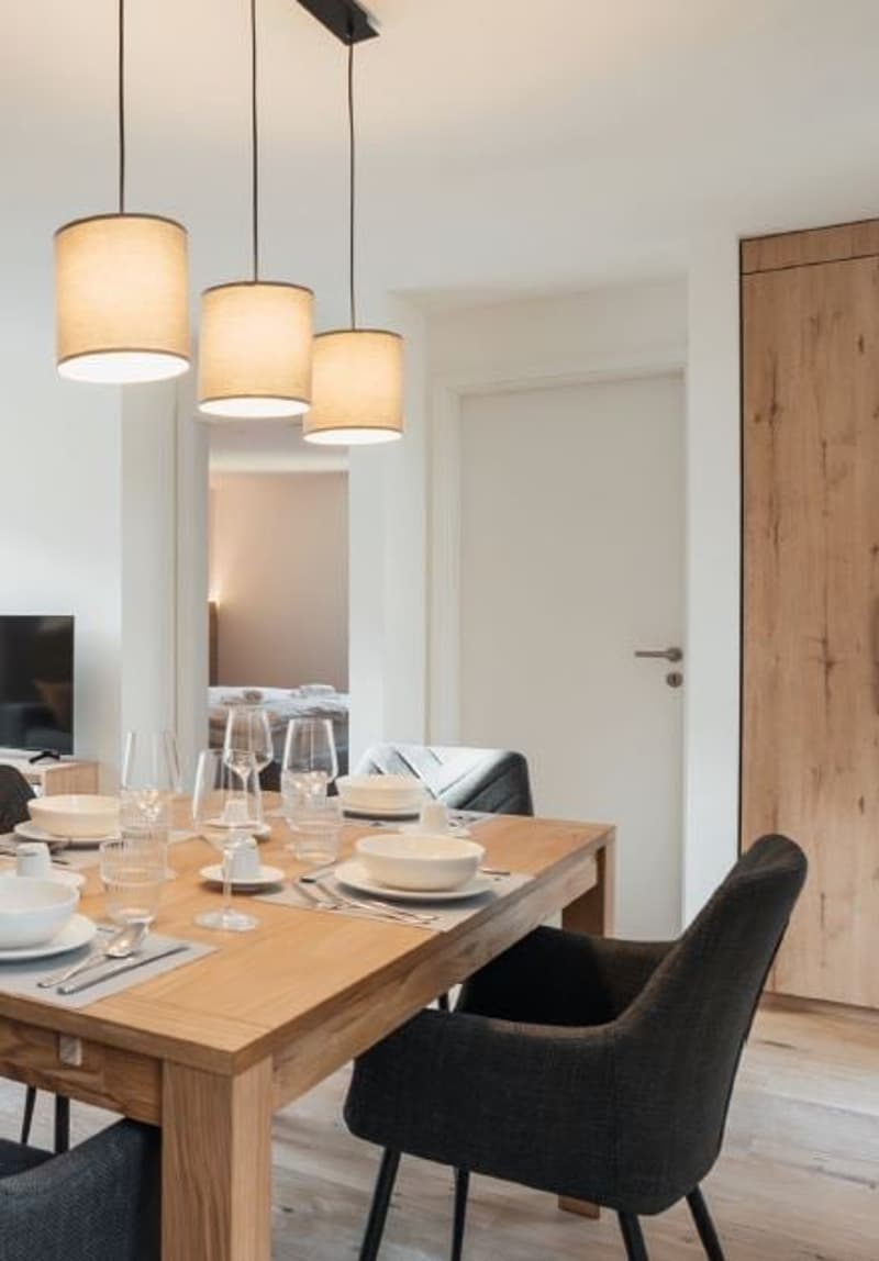 dining table, four chairs, hanging lamps, bedroom seen from the entrance