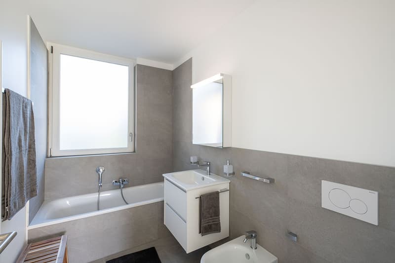 Bathroom with bathtub, sink, mirror, and toilet
