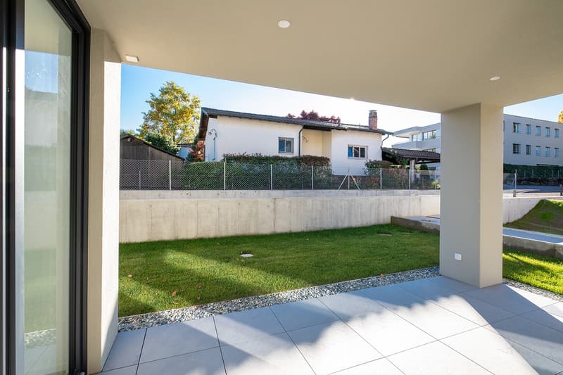 modern house, white exterior, large windows, concrete terrace, fenced garden, green grass