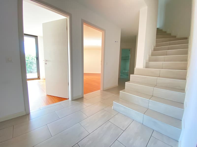 Open entrance with staircase, tiled flooring, white walls, wooden floor in entrance way