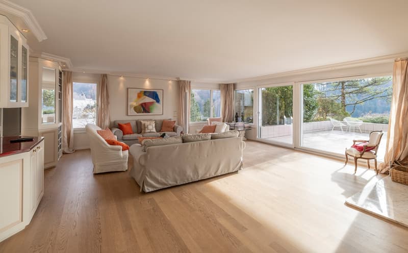 Spacious living room with large windows, hardwood floors, and a view of the outdoors.