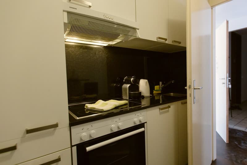 The image shows a kitchen with a Siemens oven and cooktop, a dishwasher, and various kitchen utensils on the countertop.