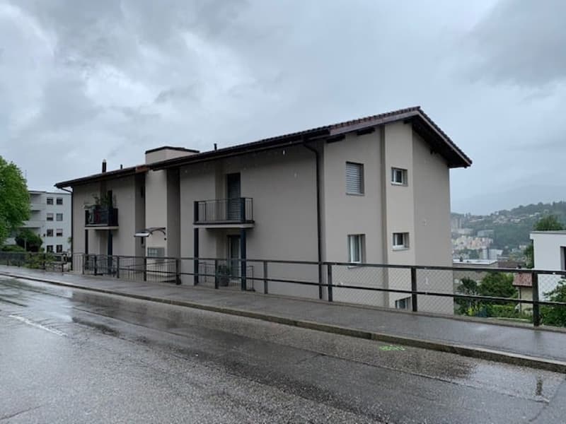 3 story house, grey walls, balconies, metal railings, metal fence