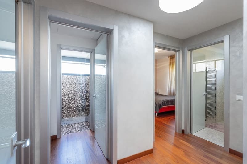 modern interior, wooden floor, glass doors, white walls, glass shower, bed, window with curtains