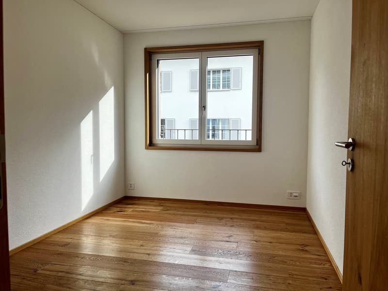 empty room, wooden floor, white walls, large window with balcony, power outlets