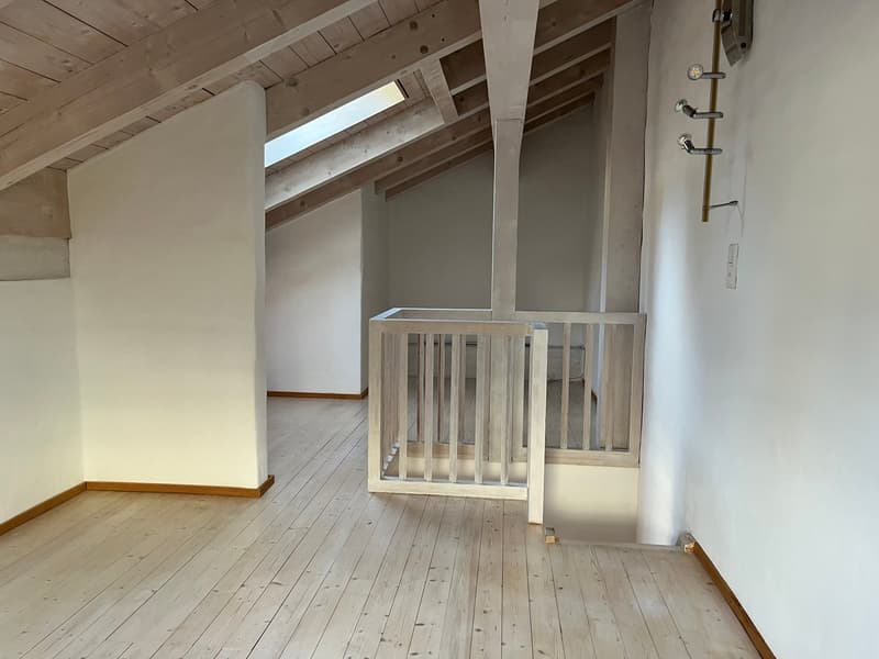 attic room, wooden beams, wooden floor, white walls, small window, wooden railing