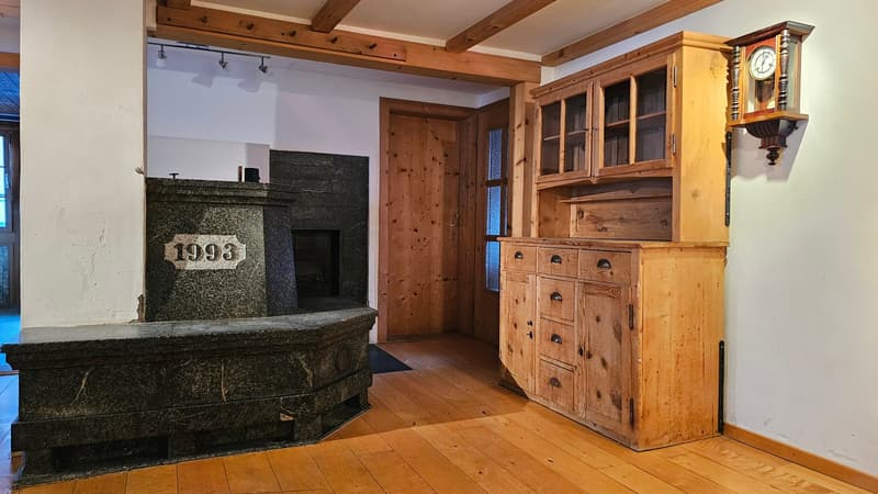 Fireplace, granite mantle, black rug, wooden floor, wooden door, wood cabinet, clock on wall
