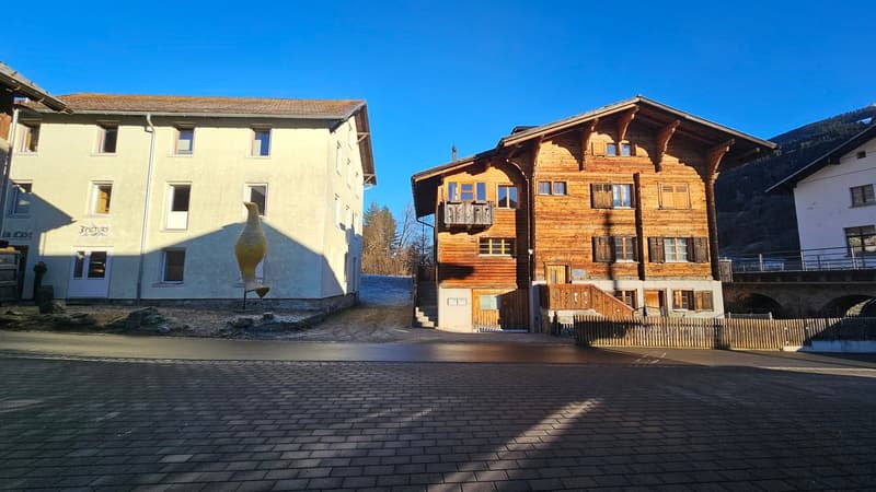 2 story house, wooden, balcony, several windows, driveway