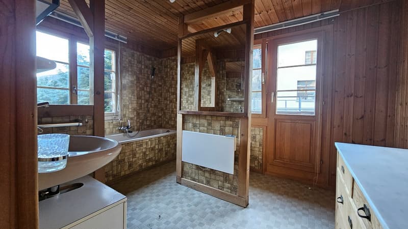 Bathtub, sink, mirror, wooden paneling, tiled flooring, washing machine