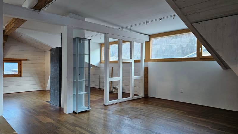 Wooden floors, white walls, multiple windows, large shelves, slanted ceiling