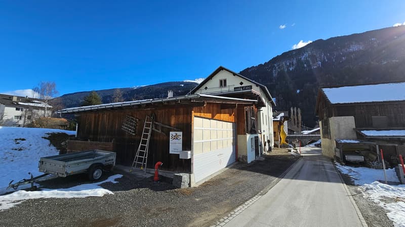 Wooden house with white walls, large garage, single story, ladder leaned against the wall