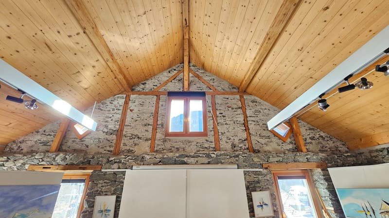 exposed wooden beams, stone walls, window, two paintings, wooden frame