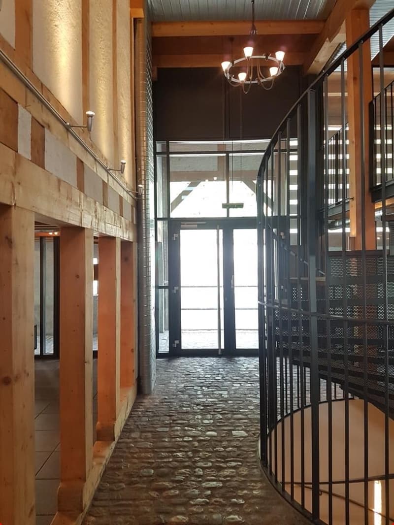 wooden beams, stone floor, chandelier, spiral staircase, glass doors