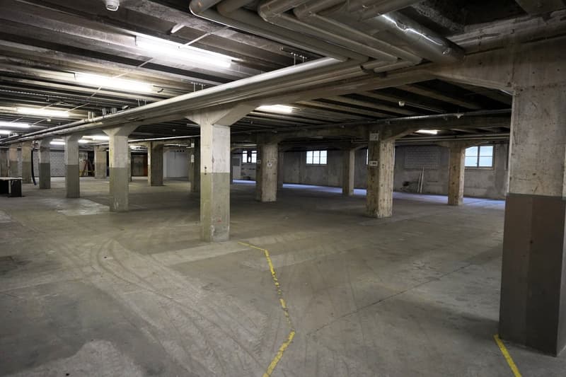 Concrete floor, concrete beams, windows, yellow lines