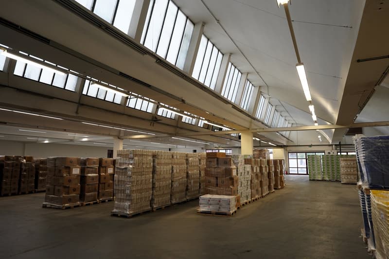 warehouse with many boxes and containers, large windows on the ceiling, spacious area