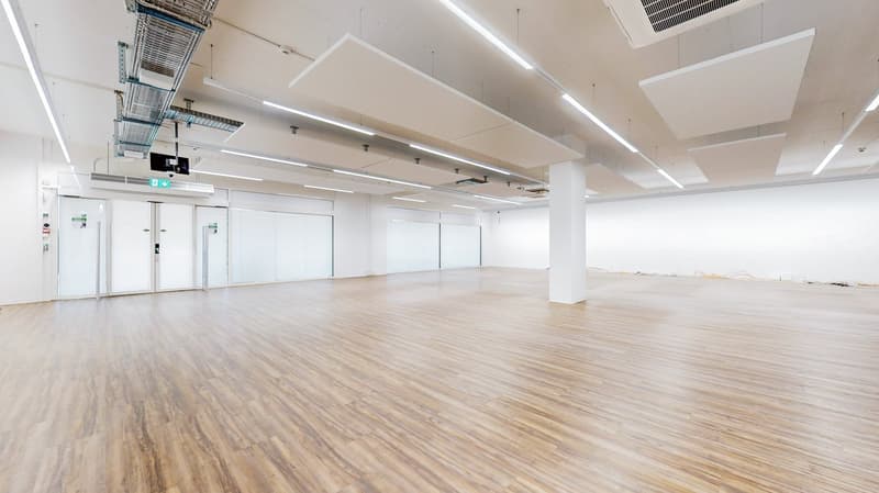 large empty room, wood floor, glass doors, lights mounted on ceiling, white walls