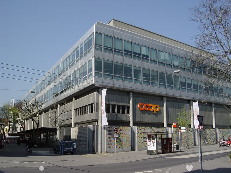modern office building with large windows, COOP banner on the front, colorful murals on the walls