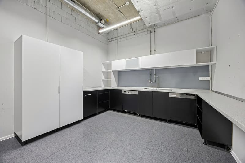 Empty kitchen with white cabinets, gray countertops, integrated dishwasher, washing machine