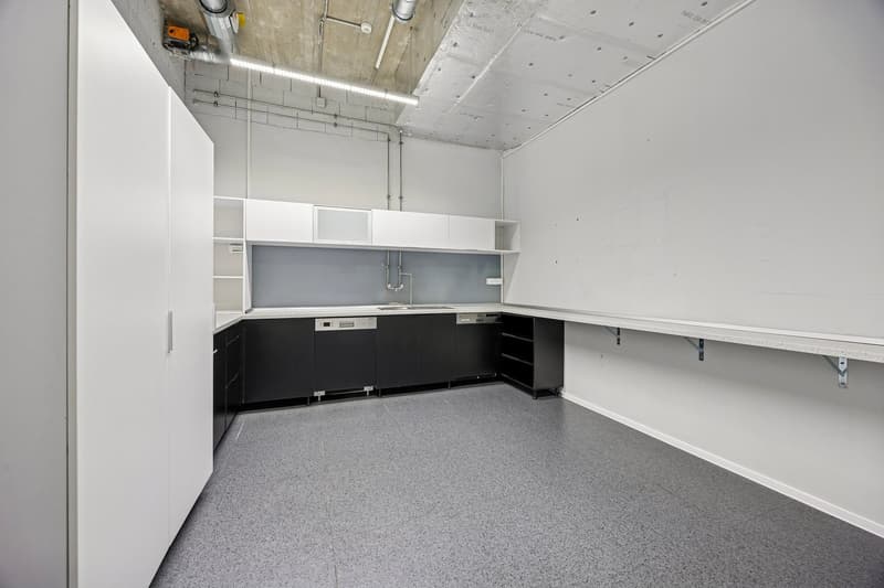 Empty kitchen with white walls, black cabinets, tiled floor, countertop, kitchen sink, dishwasher, and dishwasher