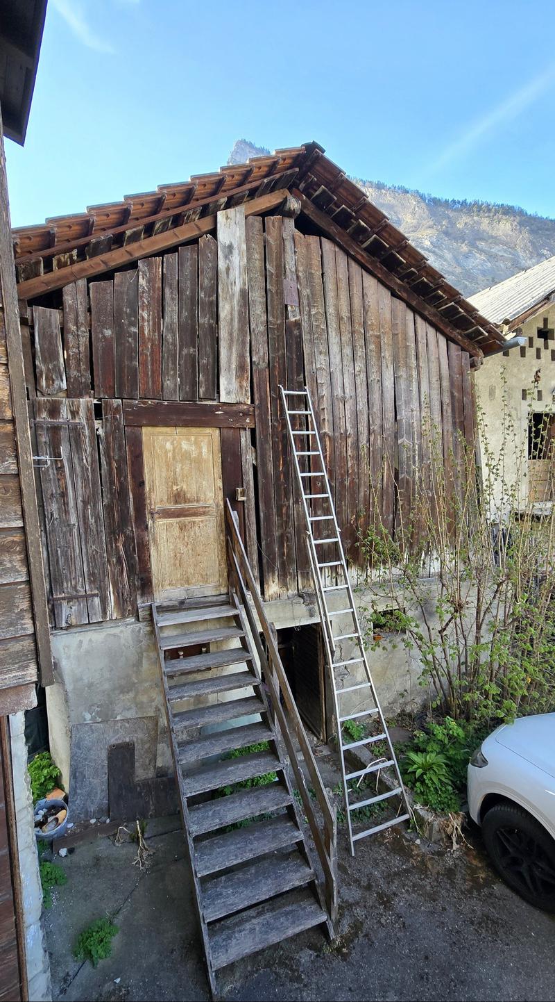 raised ground floor, wooden exterior, wooden doors, ladder, car parked