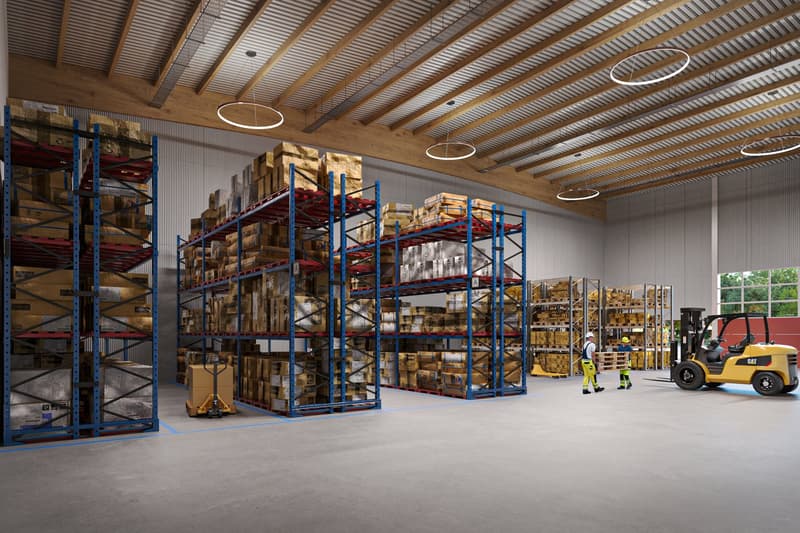 Large warehouse with high ceilings, steel shelves, forklifts, and people carrying pallets. Bright with lights on the ceiling, clear blue floor.