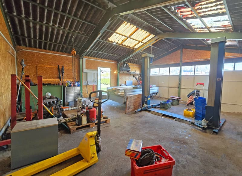 Garage with metal beams, wooden pallets, storage boxes, tools, and equipment