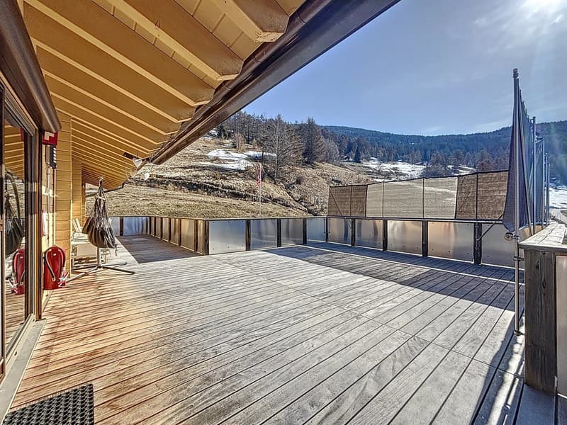 Grande terrasse lamée faisant le tour du chalet avec vue panoramique
