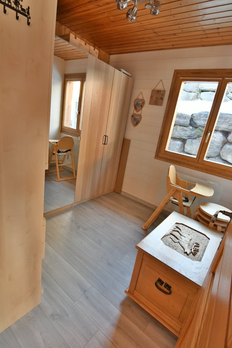 a room with wooden floor, wooden wardrobe, high ceiling, windows, dining chairs, storage box, lamp, mirror
