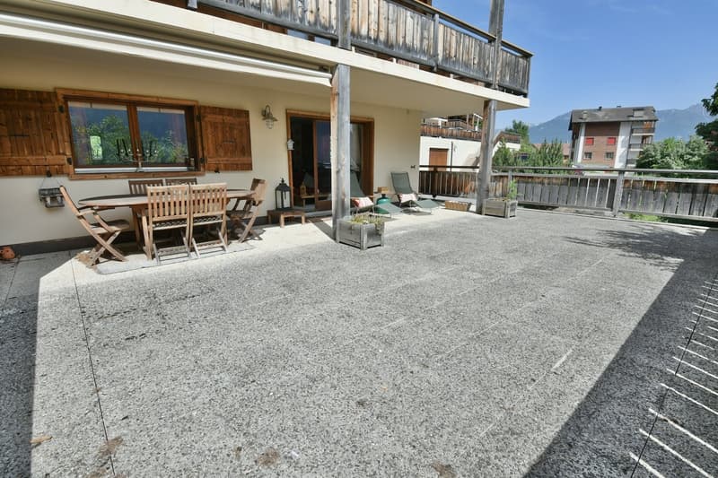 2-story wooden house with a balcony, patio furniture, and a view of the mountains