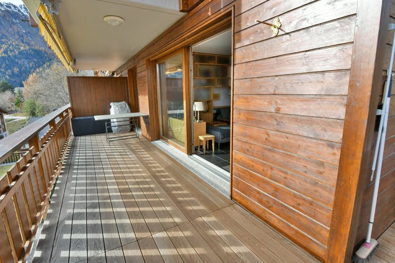 Terrace: wooden floor, wooden railing, desk, lamp, wooden walls, indoor and outdoor view