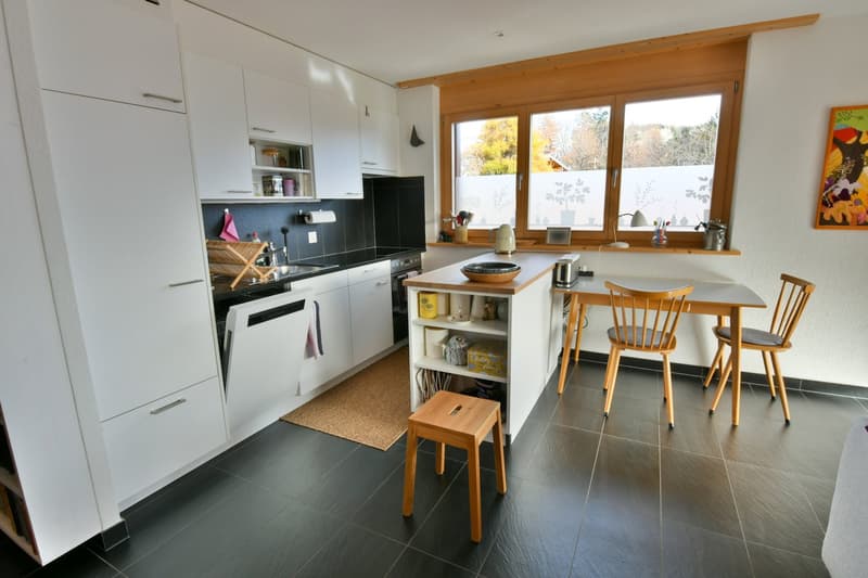 modern kitchen with wooden countertops, white cabinetry, and black tile flooring