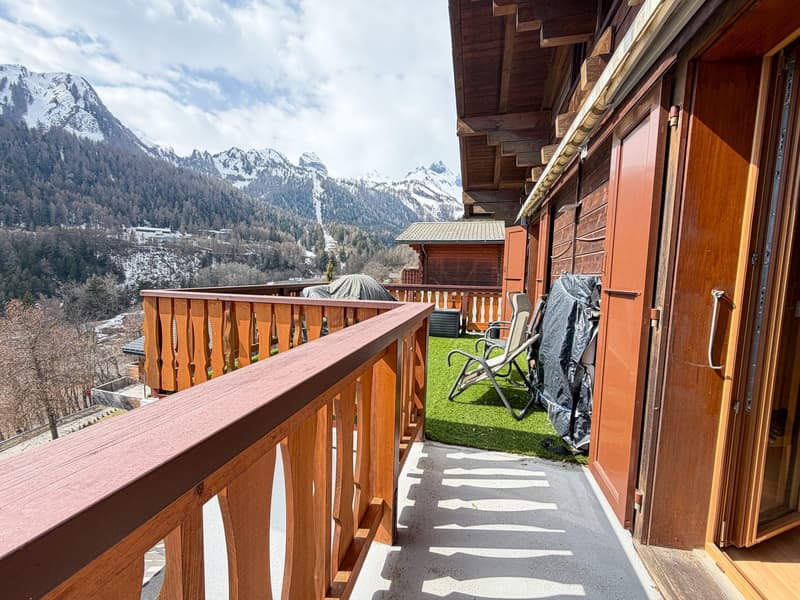 wooden balcony, wooden railing, wooden door, green grass, lounge chairs, covered grill, mountain view