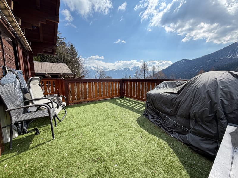 wooden railing, two lounge chairs, artificial grass, covered grill, mountain view