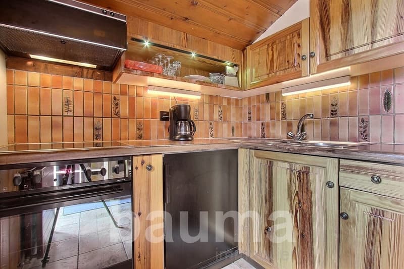Rustic wooden kitchen with tile backsplash, built-in oven, dishwasher, and coffee maker