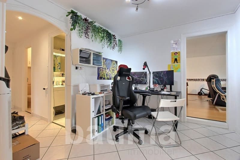 office room with desk, chair, computer, shelves, plants, and a cabinet