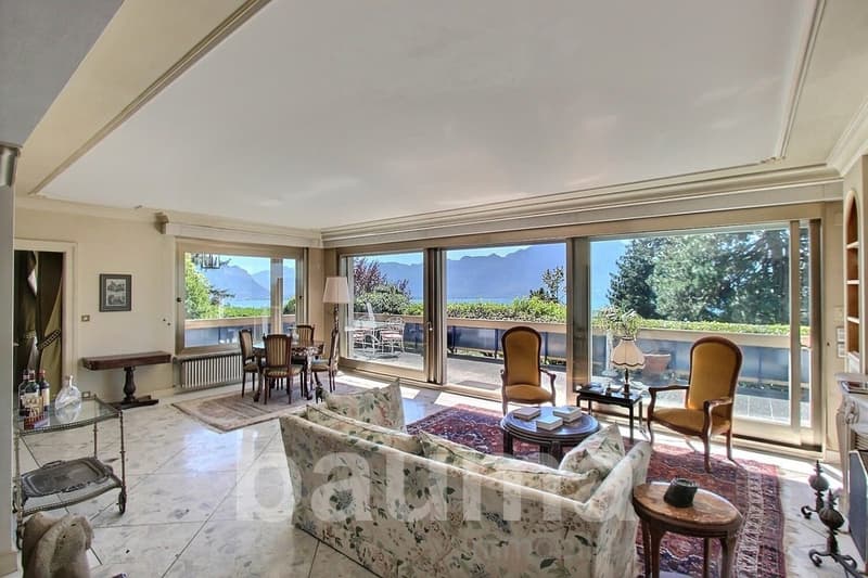 large windows, balcony, dining table, chairs, couch, carpet, table lamps, side table, radiator, picture frame, bottles