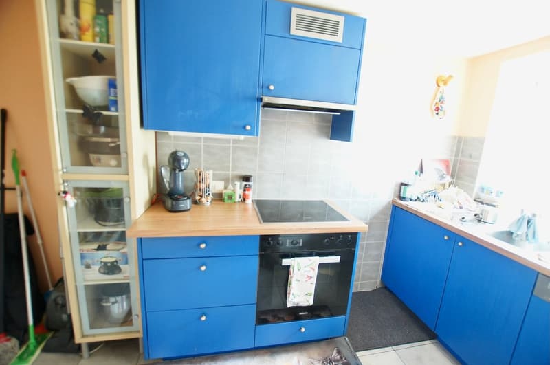 blue cabinets, countertop, stove, oven, dishwashing machine, sink, open kitchen